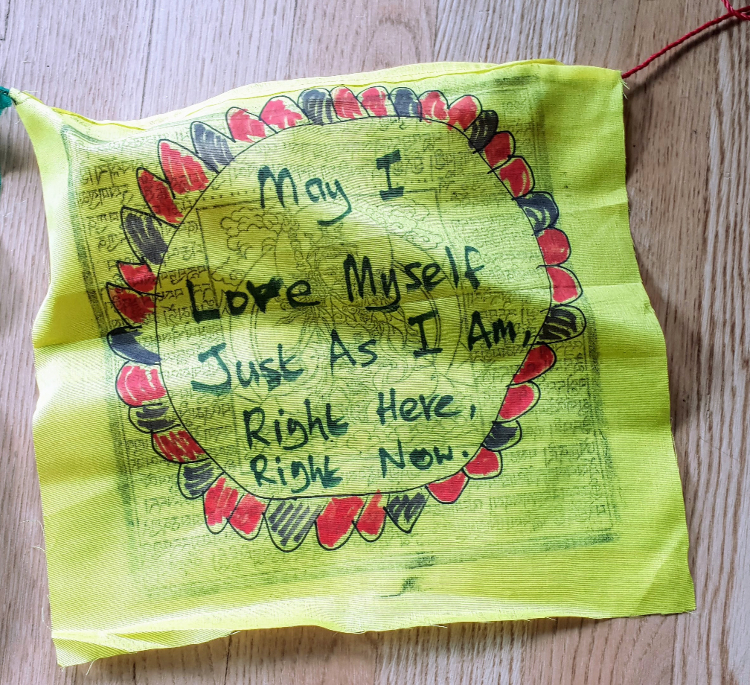 Prayer flag with handwritten message: ‘May I Love Myself Just As I Am Right Here, Right Now’