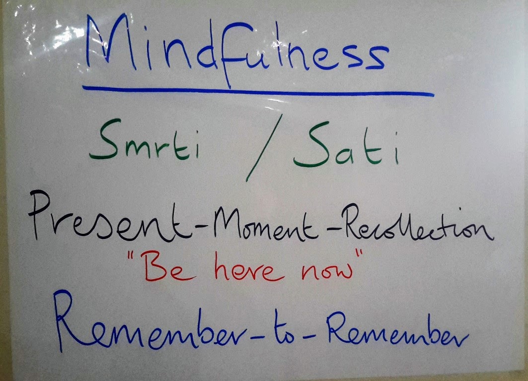 Whiteboard with handwritten notes including "Be Here Now" and "Remember-to-Remember"